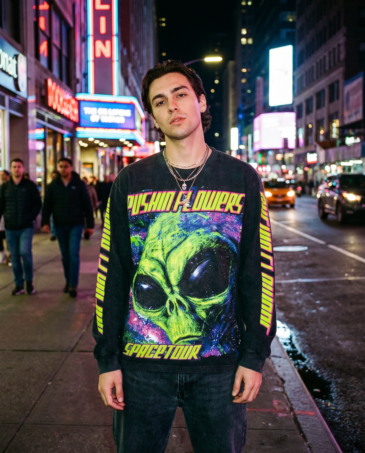 Model wearing Pushin Flowers Spacetour graphic long sleeve on a NYC street at night