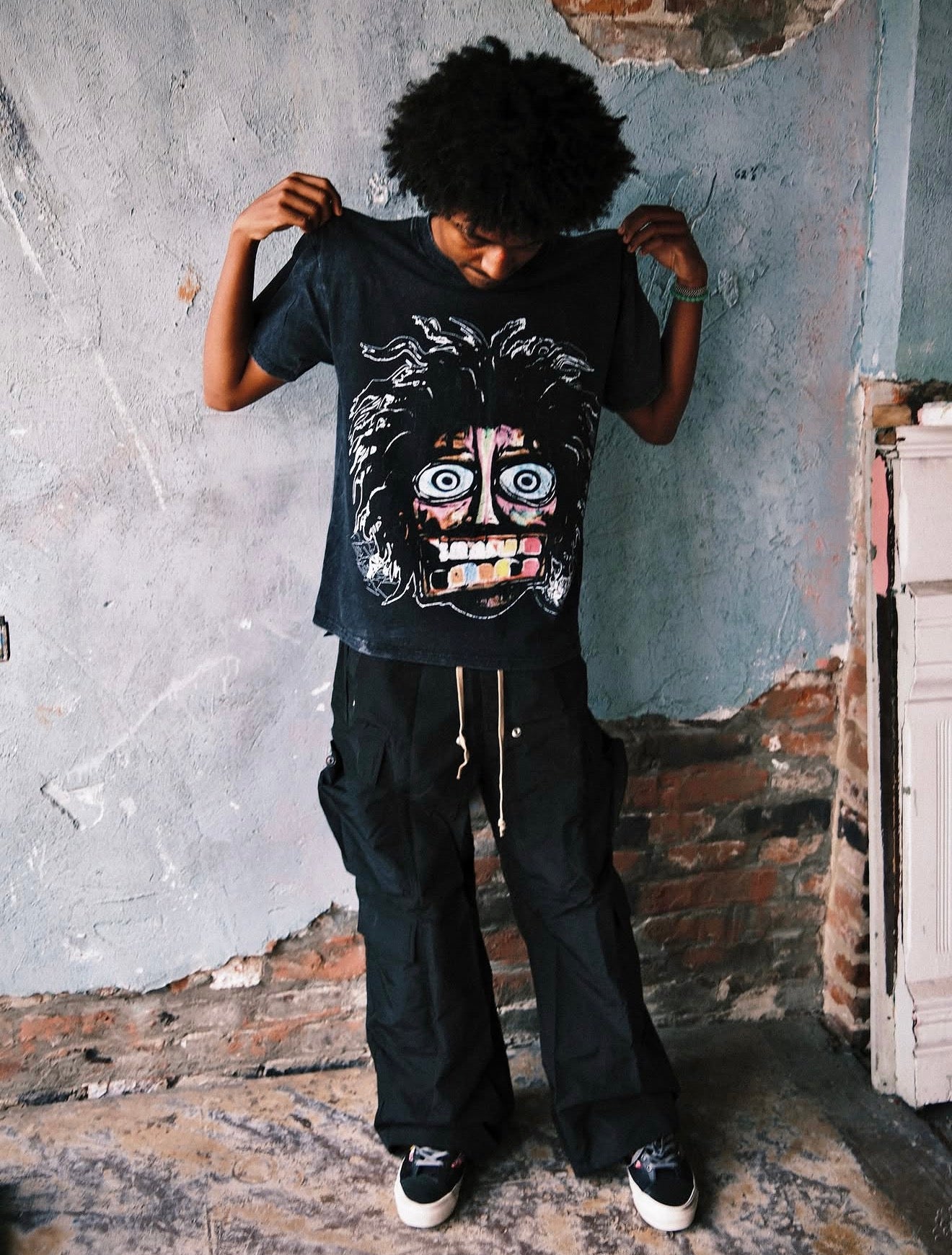 Model wearing the Acid Washed Black Crash Out tee, angled view showing the drop-shoulder oversized fit