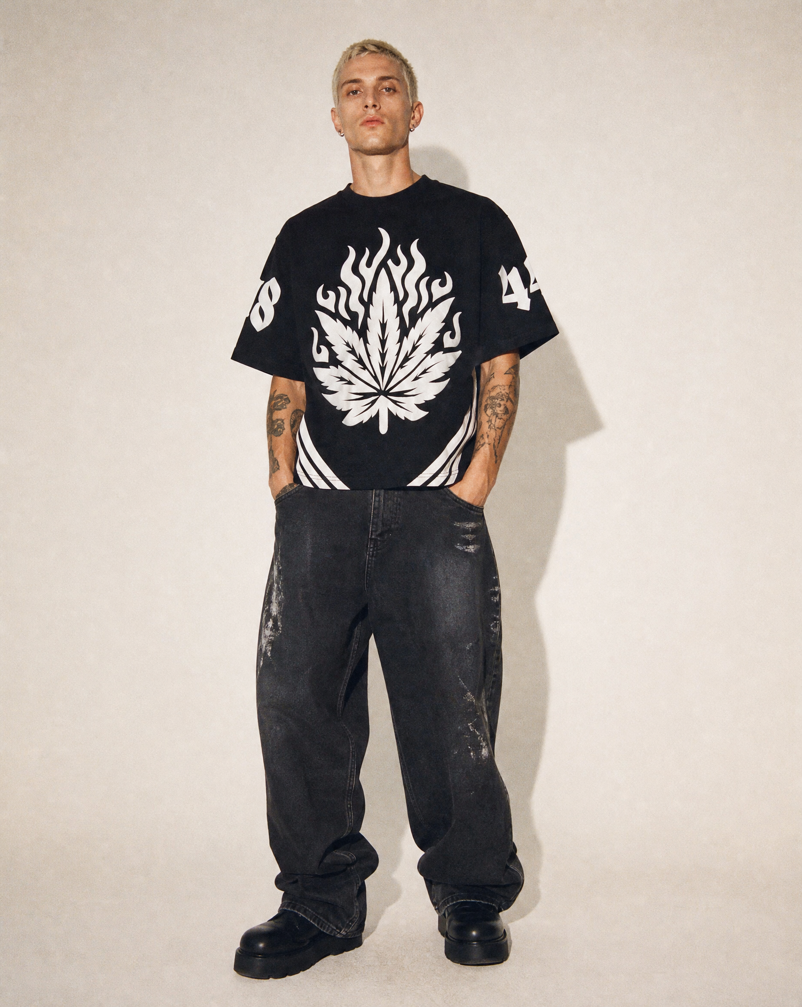 Model wearing Pushin Flowers Striped graphic shirt with white side stripes, studio streetwear photo